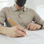 A student at Einstein International focuses on completing an exam paper, reflecting academic preparation and test readiness in a supportive environment.