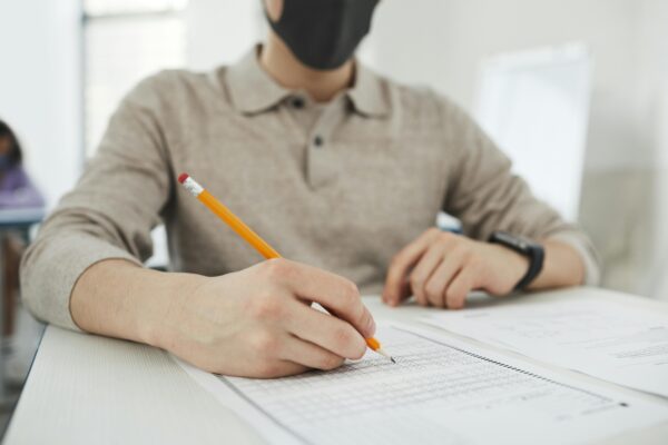 A student at Einstein International focuses on completing an exam paper, reflecting academic preparation and test readiness in a supportive environment.