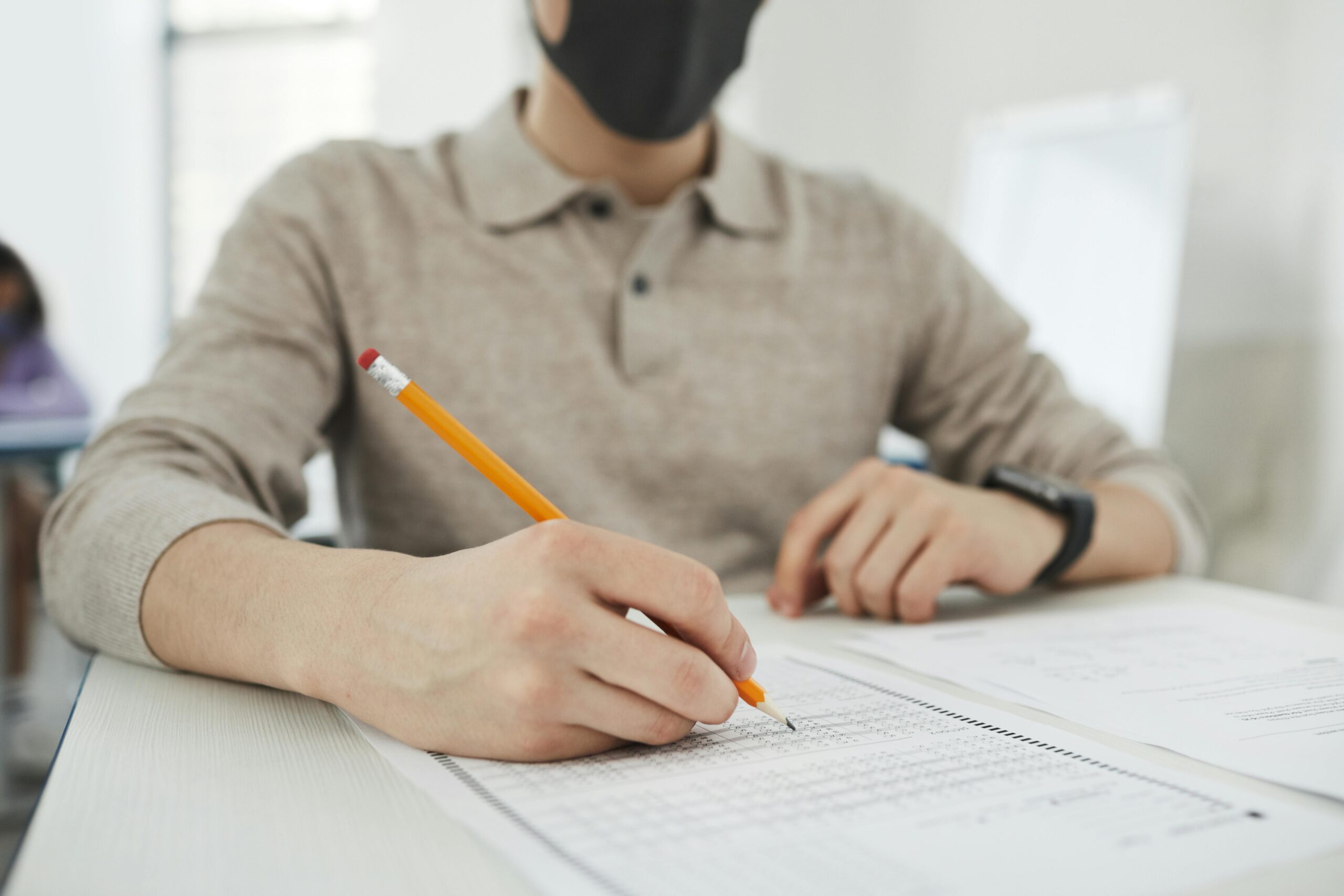 A student at Einstein International focuses on completing an exam paper, reflecting academic preparation and test readiness in a supportive environment.