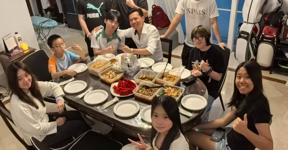 Students and mentors from Einstein International enjoying a family-style meal together, reflecting a warm and supportive learning environment.